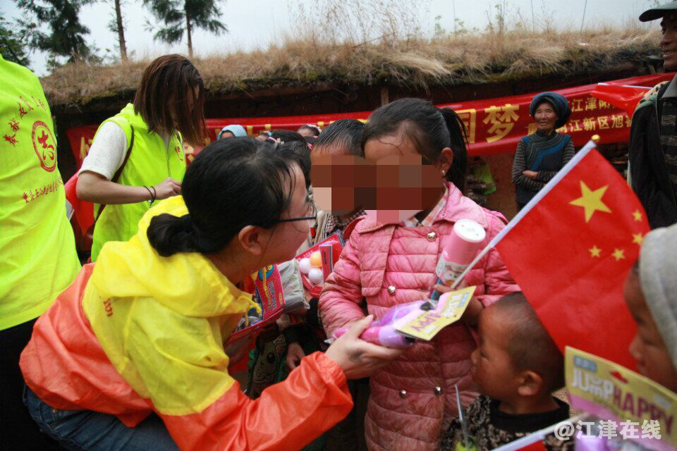 图为志愿者为孩子发礼物.png