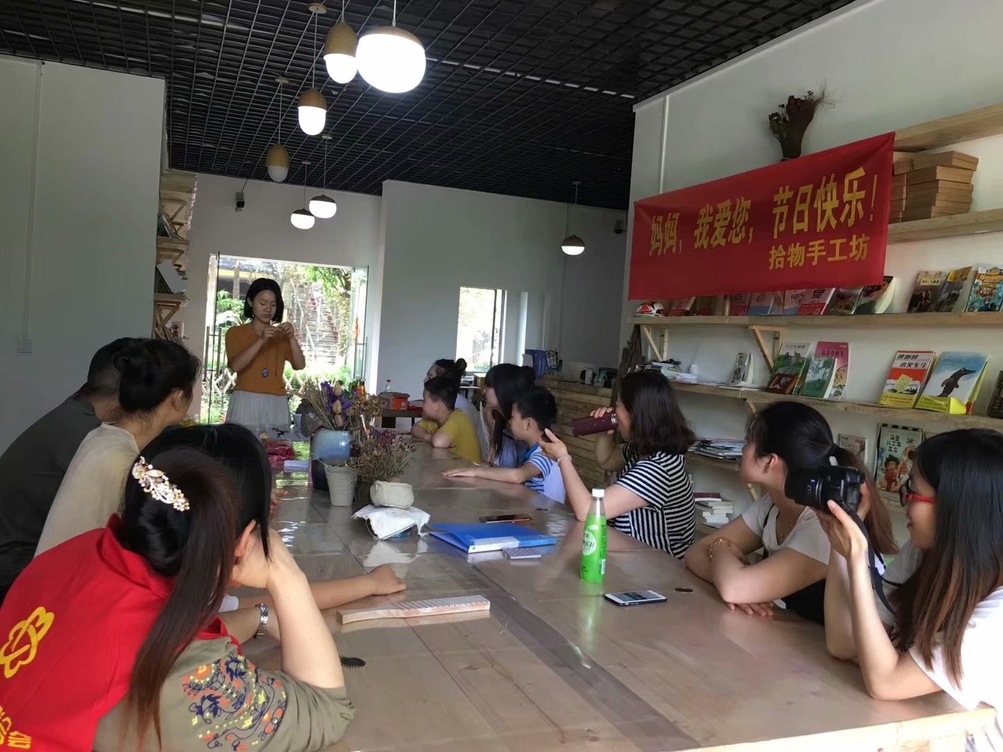 图为志愿者们学习如何制作项链.jpg
