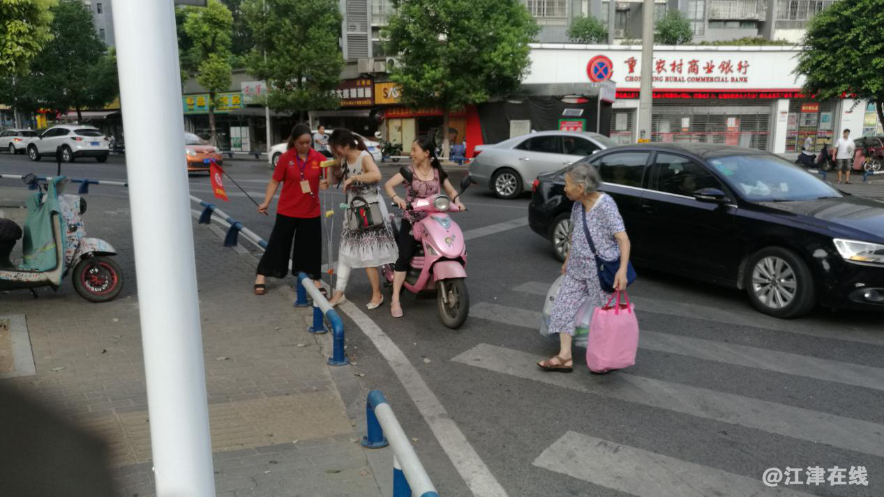 图为志愿者搀扶行动不便的行人过马路.png