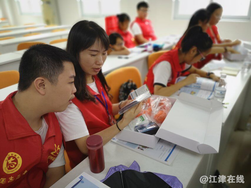 图为志愿者了解应急物品.png