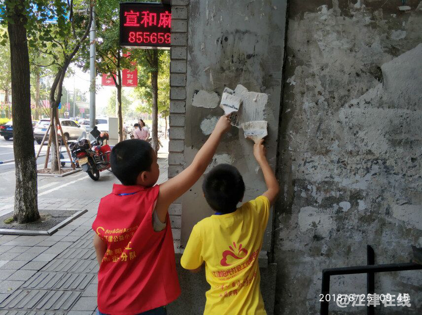 图为志愿者刷墙上的小广告.png