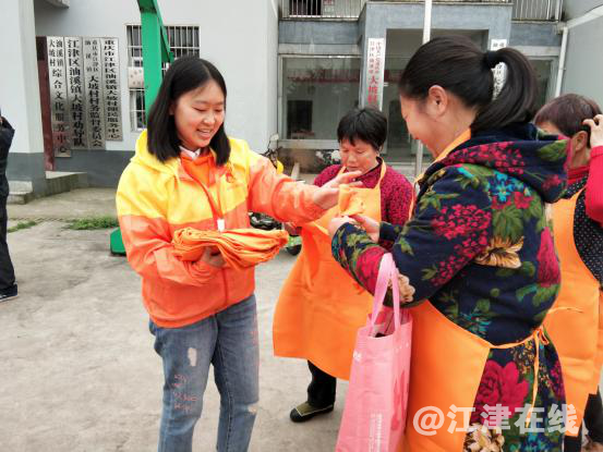 图为阳光社工为村民发放清洁工具.png
