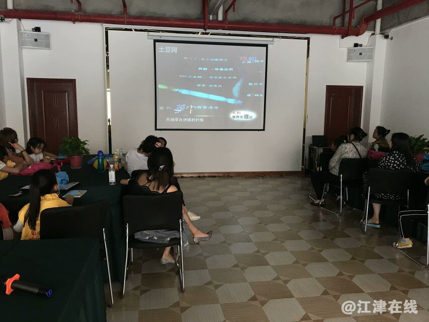 图为公益小天使及家长们观看禁烟视频.png